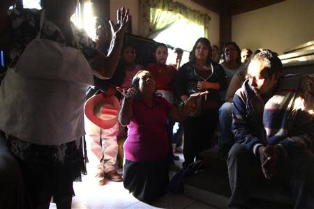 Friends and neighbors of inmate Edgar Tamayo pray inside the Tamayo family house in Micatlan, Morelos state January 22, 2014. REUTERS/Edgard Garrido