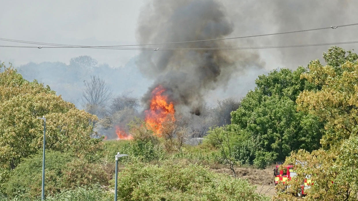 Firefighters attend a fire on Dartford Marshes in Kent. Temperatures have reached 40C for the first time on record in the UK, with 40.2C provisionally recorded at London Heathrow, the Met Office has said. Picture date: Tuesday July 19, 2022.