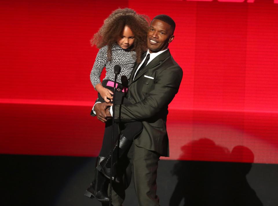 Annalise Bishop, left, and Jamie Foxx present the award for favorite rap/hip-hop album at the 42nd annual American Music Awards at Nokia Theatre L.A. Live on Sunday, Nov. 23, 2014, in Los Angeles. (Photo by Matt SaylesInvision/AP)