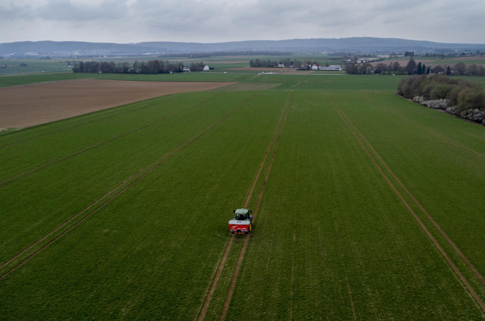 A farmer fertilizes a field on the outskirts of Frankfurt, Germany, Monday, April 4, 2022. Russia's war in Ukraine has pushed up fertilizer prices that were already high, made scarce supplies rarer still and squeezed farmers. (AP Photo/Michael Probst)