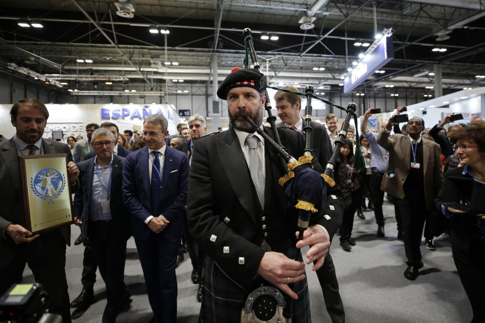 Un gaitero acompaña la delegación del Reino Unido para promover COP26, a realizarse en Glasgow, Escocia, en la cumbre sobre el clima COP25 en Madrid, viernes 13 de diciembre de 2019. (AP Foto/Paul White)