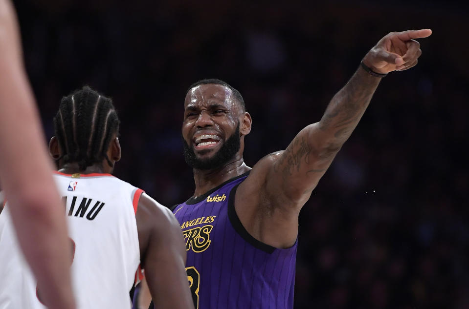 Los Angeles Lakers forward LeBron James, right, gestures to his teammates while being guarded by Portland Trail Blazers forward Al-Farouq Aminu during the second half of an NBA basketball game Wednesday, Nov. 14, 2018, in Los Angeles. The Lakers won 126-117. (AP Photo/Mark J. Terrill)