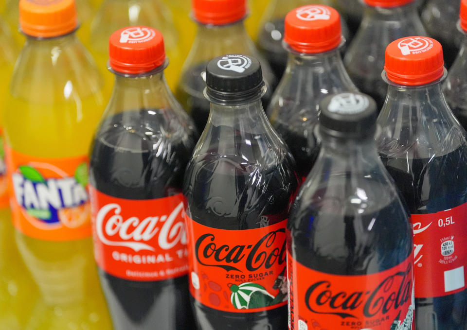 Assorted Coca-Cola and Fanta soda bottles on a shelf in a store