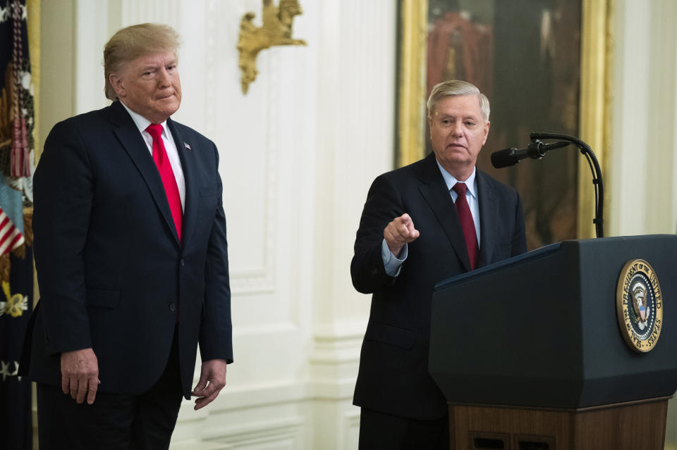 President Donald Trump listens to Sen. Lindsey Graham, R-S.C., speak during a ceremony in the East Room of the White House where Trump spoke about his judicial appointments, Wednesday, Nov. 6, 2019, in Washington. (AP Photo/Manuel Balce Ceneta)