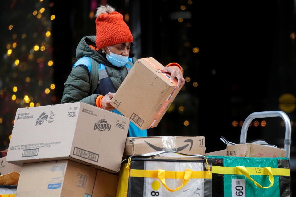 Pekerja penghantaran Amazon menyusun kotak untuk penghantaran pada troli pada Cyber-Monday di New York City, 29 Nov. 2021.