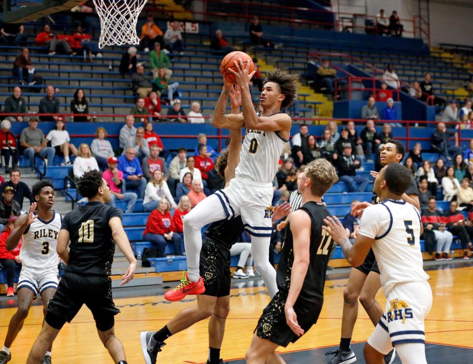 South Bend Riley senior Payton Baird (0) makes a layup while surrounded by three Mount Vernon players during a boys basketball game Saturday, Dec. 23, 2023, at Kokomo High School.