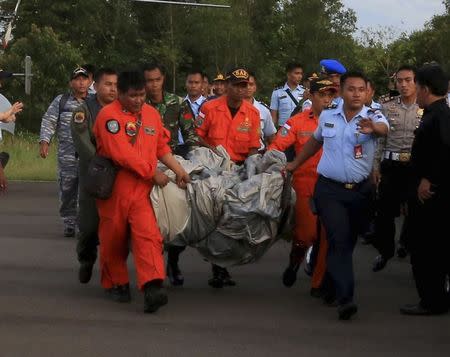 Members of the Search and Rescue Agency SARS carry debris recovered from the sea presumed from missing Indonesia AirAsia flight QZ 8501 at Pangkalan Bun, Central Kalimantan, December 30, 2014 in this photo taken by Antara Foto. REUTERS/Antara Foto/Kenarel