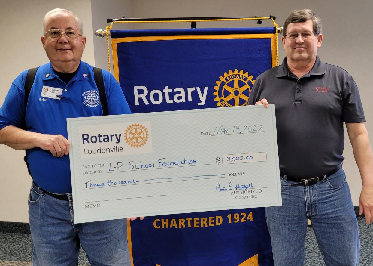 Loudonville Rotary President Brian Hartzell presents an oversized check for $3,000 to L-P School Foundation President Mike Bandy on May 19. Money is toward the Foundation's $100,000 challenge grant from the Ramser family.