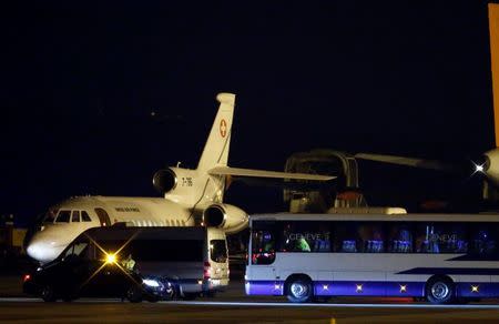 A bus and a van are parcked in front of a plane carrying three Iranian-Americans, who left Tehran under a prisoner swap, after it landed at Cointrin airport in Geneva, Switzerland January 17, 2016. REUTERS/Denis Balibouse