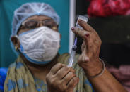 A health worker fills a syringe with a dose of Covaxin COVID-19 vaccine at a health center in Garia , South 24 Pargana district, India, Thursday, Oct. 21, 2021. India has administered 1 billion doses of COVID-19 vaccine, passing a milestone for the South Asian country where the delta variant fueled its first crushing surge this year. (AP Photo/Bikas Das)