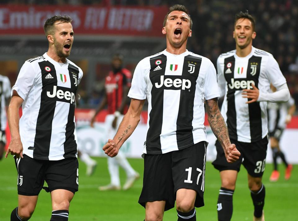 Juventus' Mario Mandzukic, center, celebrates after he scored his side's first goal during a Serie A soccer match between AC Milan and Juventus, at Milan's San Siro stadium, Sunday, Nov. 11, 2018. (Daniel Dal Zennaro/ANSA via AP)DANIEL DAL ZENNARO