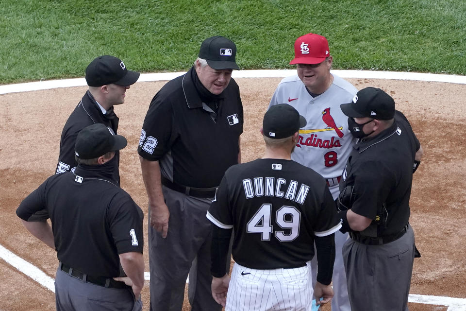 Umpire Joe West (22) talks with Chicago White Sox analytics coordinator Shelley Duncan (49) and St. Louis Cardinals manager Mike Shildt (8) as West's crew of Bruce Dreckman (1) Nic Lentz (59) and Dan Bellino listen before an interleague baseball game Monday, May 24, 2021, in Chicago. West now ties the major league record for games umpired. (AP Photo/Charles Rex Arbogast)