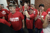 Workers from the Quaker Oats plant in Cedar Rapids, Iowa, react as their winning $241 million Powerball ticket is scanned at the Iowa Lottery headquarters, Wednesday, June 20, 2012, in Des Moines, Iowa. Lottery spokeswoman Mary Neubauer says one of the workers bought the winning ticket for the group for the June 13 drawing and the winnings will be split 20 ways.(AP Photo/Charlie Neibergall)