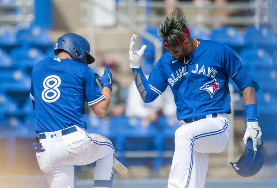 Toronto Blue Jays' Cavan Biggio (8) and Lourdes Gurriel Jr. celebrate Gurriel's solo home run against the Philadelphia Phillies during the fourth inning of a spring training baseball game, Tuesday, March 2, 2021, at TD Ballpark in Dunedin, Fla. (Steve Nesius/The Canadian Press via AP)