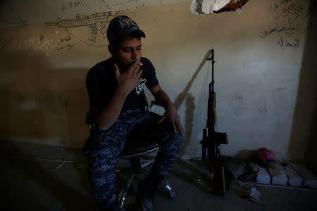 A member of the Iraqi federal police smokes during clashes with Islamic State militants, in Mosul, Iraq March 25, 2017. Picture taken March 25, 2017. REUTERS/Khalid al Mousily