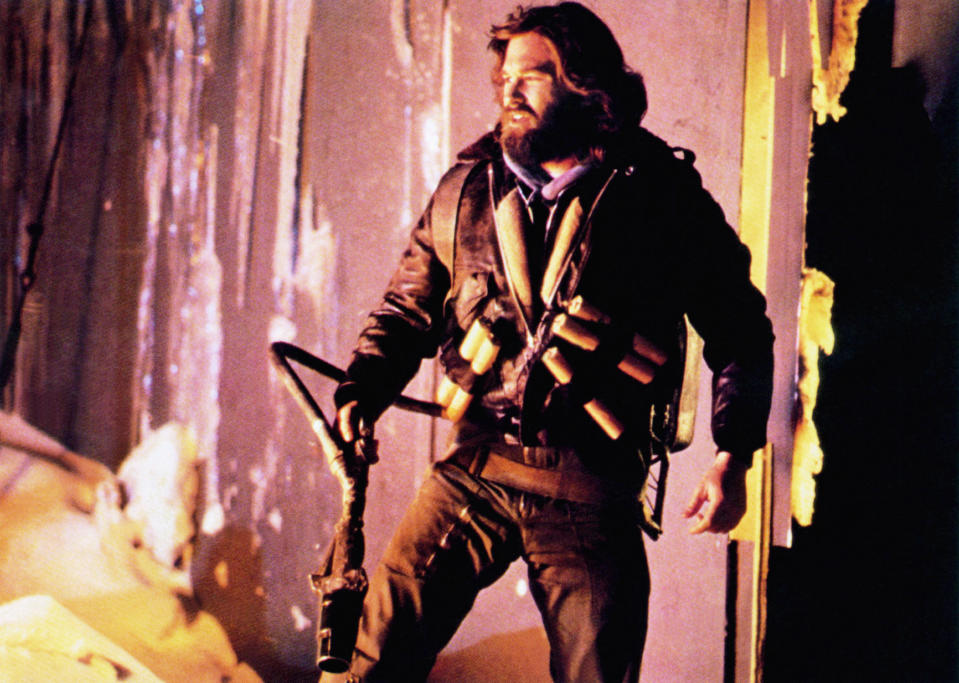 Kurt Russell staring at a fire.