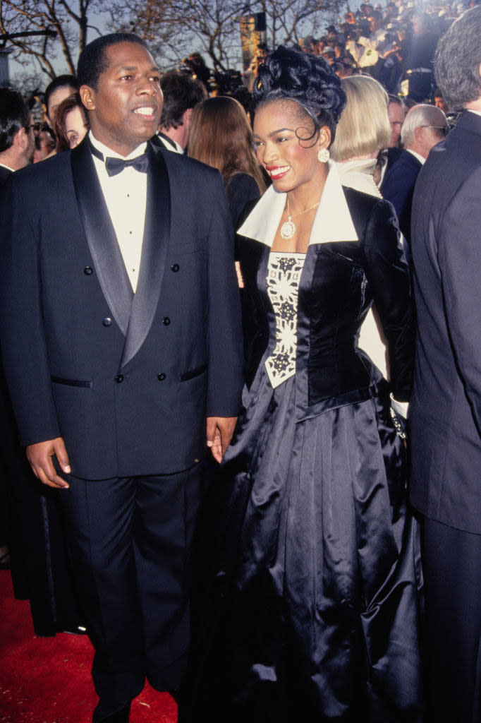 Angela on the red carpet in a satiny flared, long-sleeved gown