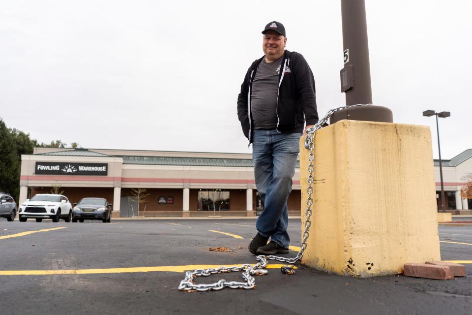 Fowling Warehouse co-owner Scott Brown stands by a chain and cut lock where a 16-foot-long trailer was stolen from the Fowling Warehouse in Ypsilanti spot where it was parked on Friday, November 3, 2023. Two thieves pulled into the parking lot of the Fowling Warehouse Ypsi Ann Arbor in a U-Haul truck and helped themselves to the business' 16-foot-long trailer, identifiable by the name and logo on the side and the bullet hole in the left rear door.