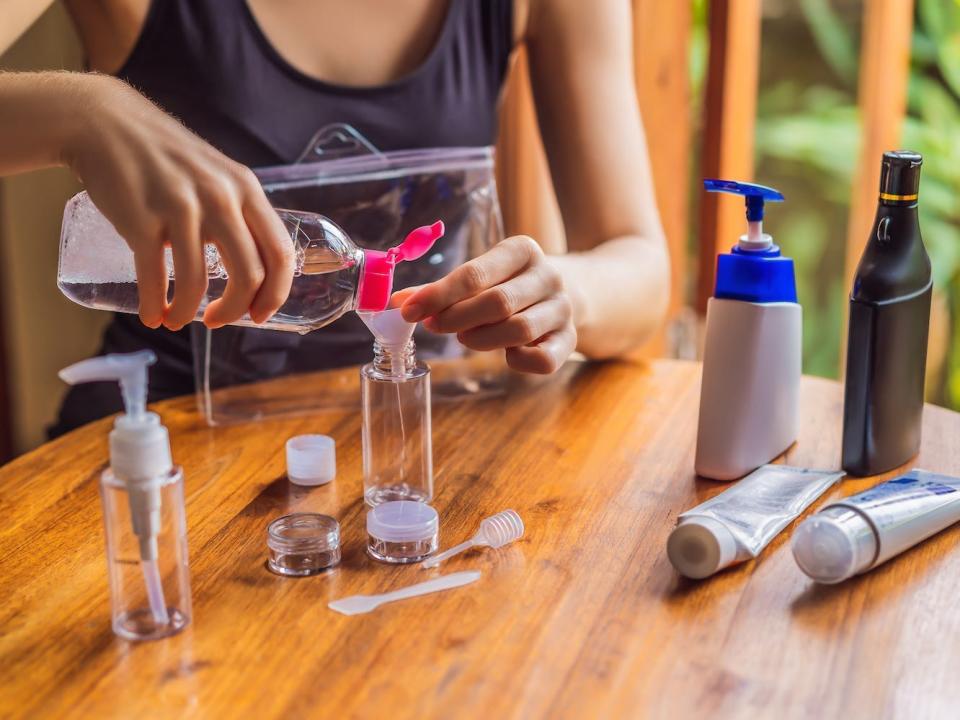 A person fills up reusable toiletry bottles.