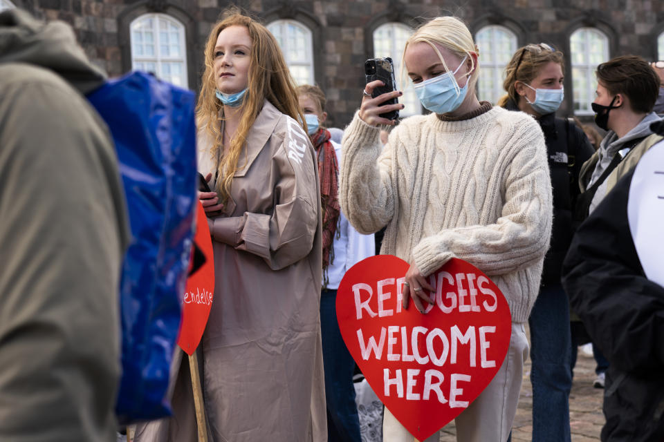 People attend a demonstration against the tightening of Denmark's migration policy and the deportation orders in Copenhagen, Denmark, Wednesday, April 21, 2021. Ten years after the start of the Syrian civil war, Denmark has become the first European country to start revoking the residency permits of some refugees from the Damascus area. (AP Photo/David Keyton)