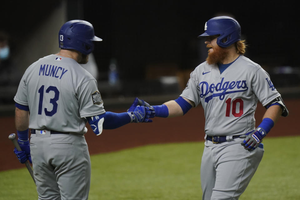 Los Angeles Dodgers' Justin Turner celebrates his home run with Max Muncy against the Tampa Bay Rays during the first inning in Game 3 of the baseball World Series Friday, Oct. 23, 2020, in Arlington, Texas. (AP Photo/Eric Gay)