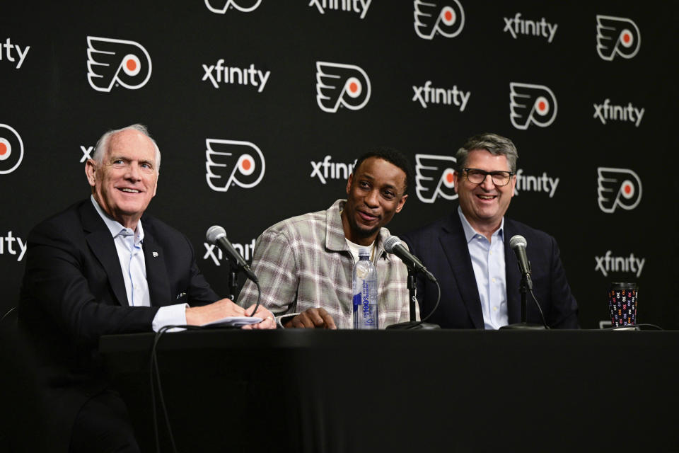 Former Philadelphia Flyers' Wayne Simmonds, center, with Flyers Governor and CEO of Comcast Spectacor Dan Hilferty, left, and President of Hockey Operations Keith Jones, right, answers questions during a press conference prior to an NHL hockey game, Saturday, April 13, 2024, in Philadelphia. Simmonds signed a one-day contract retiring a Philadelphia Flyer. (AP Photo/Derik Hamilton)