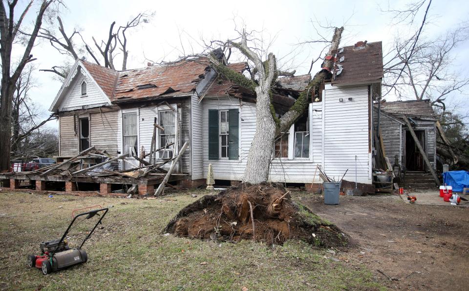 A house is damaged by an uprooted tree on Mabry St. in Selma, Ala., Friday, Jan. 13, 2023, after a tornado passed through the area. Rescuers raced Friday to find survivors in the aftermath of a tornado-spawning storm system that barreled across parts of Georgia and Alabama.