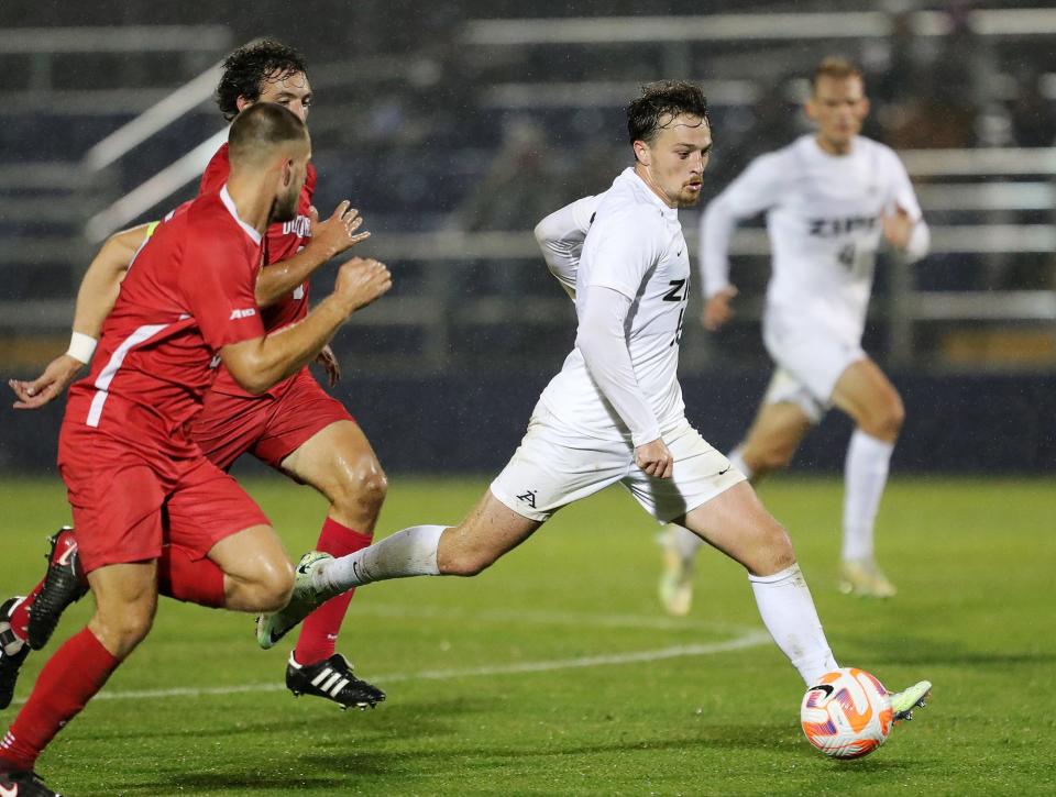 Akron midfielder Dyson Clapier (19) advances down the field ahead of a host of Duquesne players during the second half of an NCAA soccer match, Wednesday, Sept. 28, 2022, in Akron, Ohio.