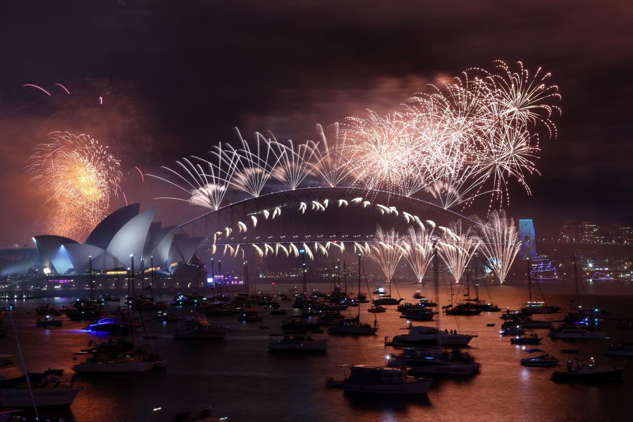 New Year's Eve fireworks light up the sky over the Sydney Opera House (L) and Harbour Bridge during the fireworks display in Sydney on January 1, 2023. (AFP via Getty Images)