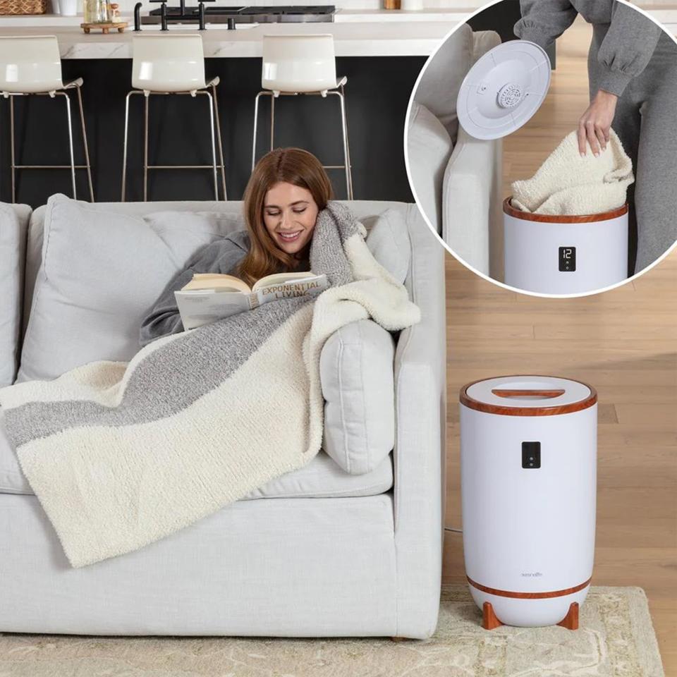 Person relaxing with a book under a blanket, next to a portable space heater