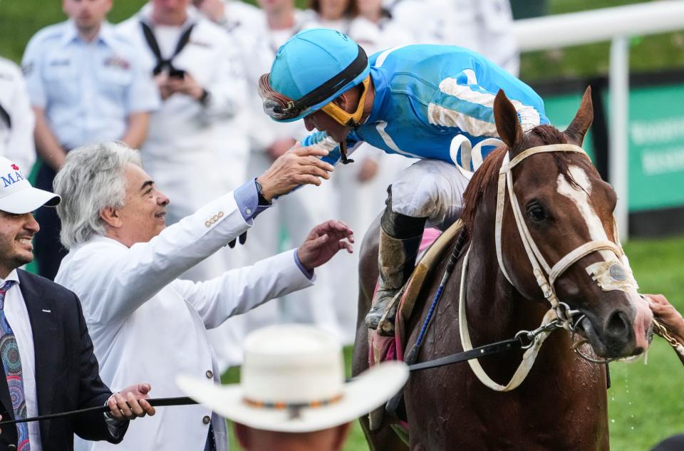 Trainer Gustavo Delgado reaches for jockey Javier Castellano after Mage won the 149th Kentucky Derby Saturday at Churchill Downs in Louisville, Ky. May, 6, 2023.