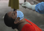 A woman gets nasal swab sample taken to test for the coronavirus at a government health center in Hyderabad, India, Wednesday, July 15, 2020. As India’s coronavirus caseload approaches 1 million, lockdowns are being reimposed in parts of the country as governments try to shield the health system from being overwhelmed. (AP Photo/Mahesh Kumar A.)