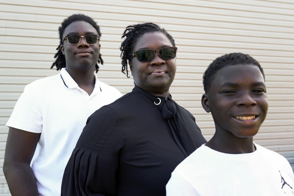 Joelle Wright-Terry poses with her sons Joshua and Micah in Clinton Township, Mich., Thursday, Sept. 17, 2020. As the U.S. surpasses its 200,000th pandemic death, the losses are taking shape in heartbreaking ways. “My dad was my best friend,” Joshua says about Marshall Terry III, who died in April from symptoms of coronavirus. “My goal is to make him proud while he watches from heaven.” (AP Photo/Paul Sancya)