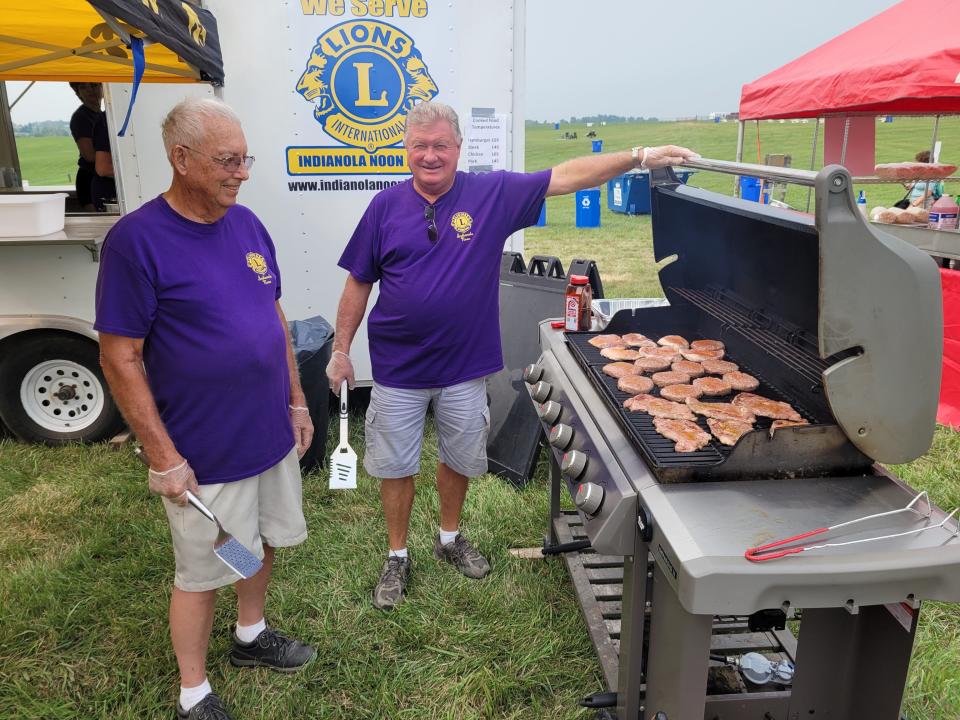 Indianola Noon Lions Club members Don Freeman, left, and Gary Downey, right, manage the grill at the National Balloon Classic in July 2021. The new grill is about twice the size as this grill.