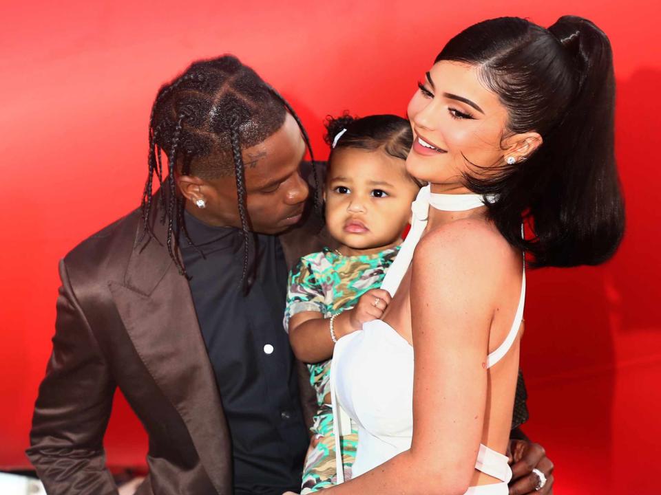 <p>Tommaso Boddi/Getty</p> Travis Scott and Kylie Jenner with their daughter Stormi Webster at the 