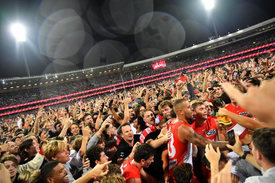 Lance Franklin of the Swans is surrounded by fans after kicking his 1000th goal during a 2022 match against Geelong Cats at the SCG