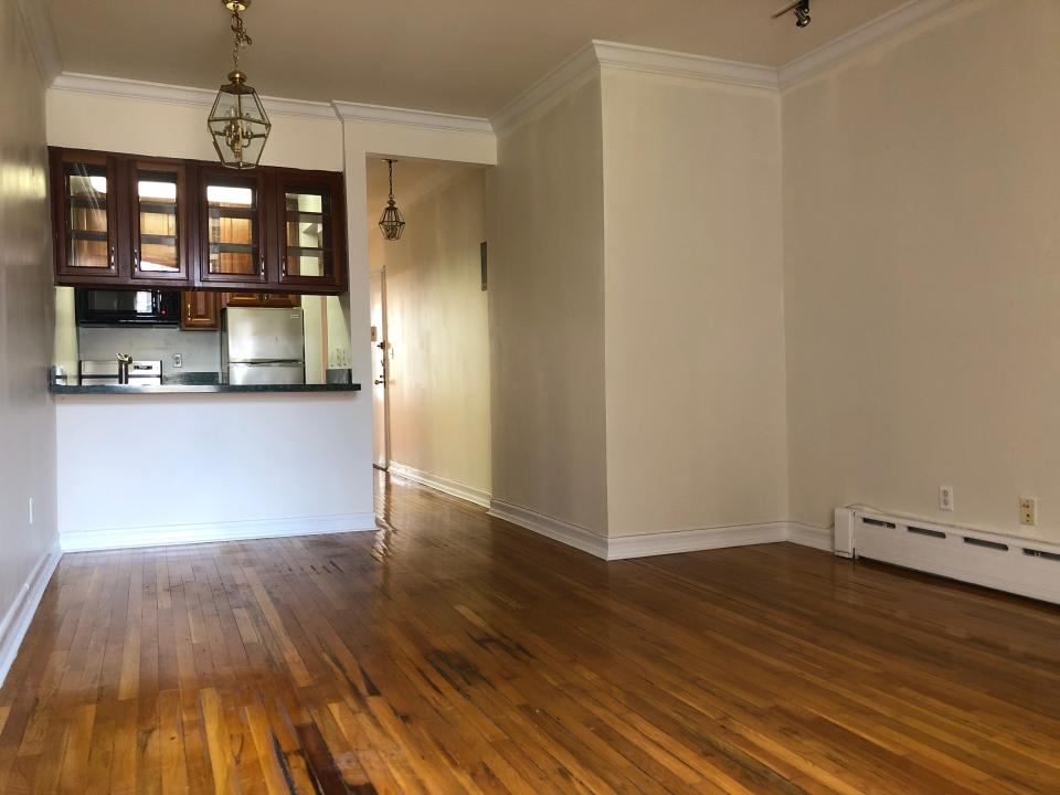 the empty living room and kitchen in the new york apartment