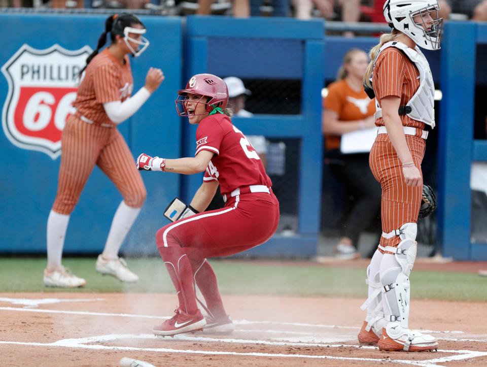 Oklahoma's Jayda Coleman (24) slides home to score a run beside Texas utility Reese Atwood (14) in the first inning of the Big 12 softball tournament championship game between the University of Oklahoma Sooners (OU) and Texas Longhorns at Devon Park in Oklahoma City, Saturday, May 11, 2024. Oklahoma won 5-1.