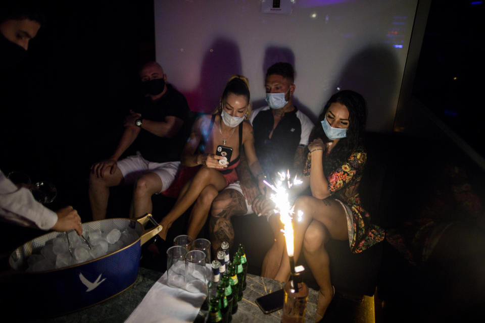 People wearing face masks to prevent the spread of coronavirus gather in a nightclub in Madrid, Spain, early Saturday, July 25, 2020. (AP Photo/Manu Fernandez)
