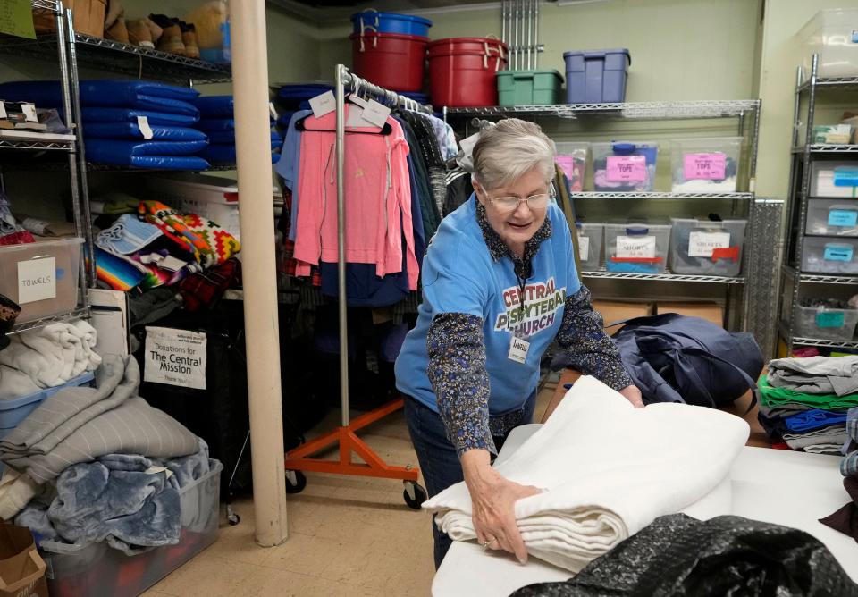 Janelle Collier, a volunteer at the clothing closet at Central Presbyterian Church, gathers blankets Thursday. The Cold Weather Collaborative organizes the collection and distribution of cold weather gear and hot meals.