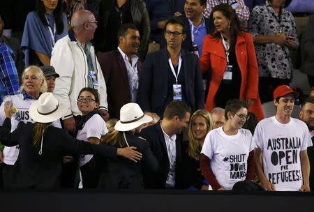 Spectators and security staff react as protesters display slogans on their t-shirts during the men's singles final match between Novak Djokovic of Serbia and Andy Murray of Britain at the Australian Open 2015 tennis tournament in Melbourne February 1, 2015. REUTERS/Issei Kato