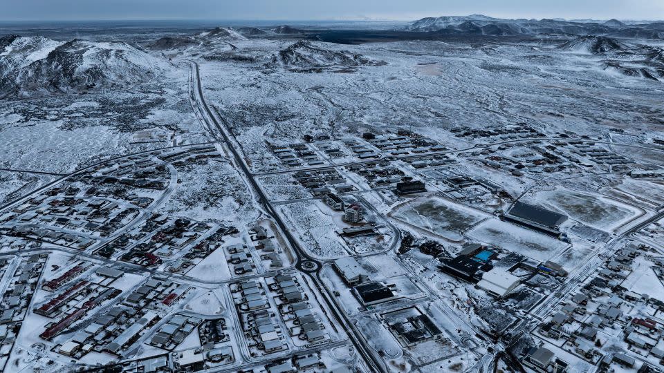 The lava field produced by volcanic activity can be seen in the top background above Grindavik on Iceland's Reykjanes Peninsula, on December 21, 2023. - Marco Di Marco/AP