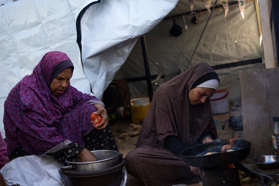 Randa Baker, right, who was displaced by the Israeli bombardment of the Gaza Strip, prepares the Iftar meal with her mother on the first day of the Muslim holy fasting month of Ramadan at a makeshift tent camp in the Muwasi area, southern Gaza, on March 11, 2024. The holy month, typically a time of communal joy and reflection, is overshadowed by the grim reality of a conflict that has claimed over 30,000 Palestinian lives and left vast swaths of Gaza in shambles.