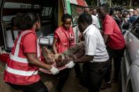 An injured member of the security forces is evacuated from the scene