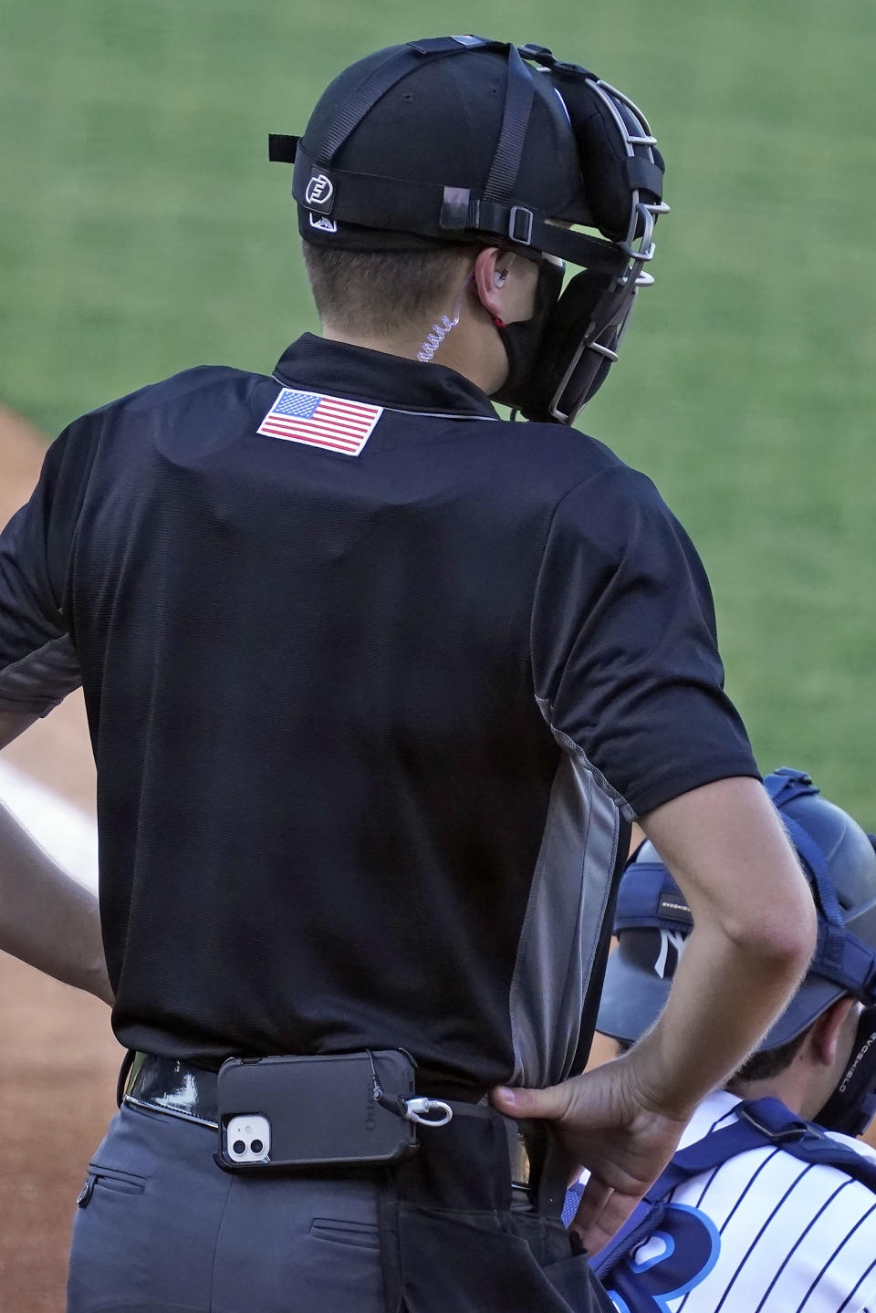 Home plate umpire Kaleb Devier wears an earpiece and a battery pack during a Low A Southeast League baseball game between the Dunedin Blue Jays and the Tampa Tarpons at George M. Steinbrenner Field Tuesday, May 4, 2021, in Tampa, Fla. The game is one of the first in the league to use automatic balls and strike calls. (AP Photo/Chris O'Meara)