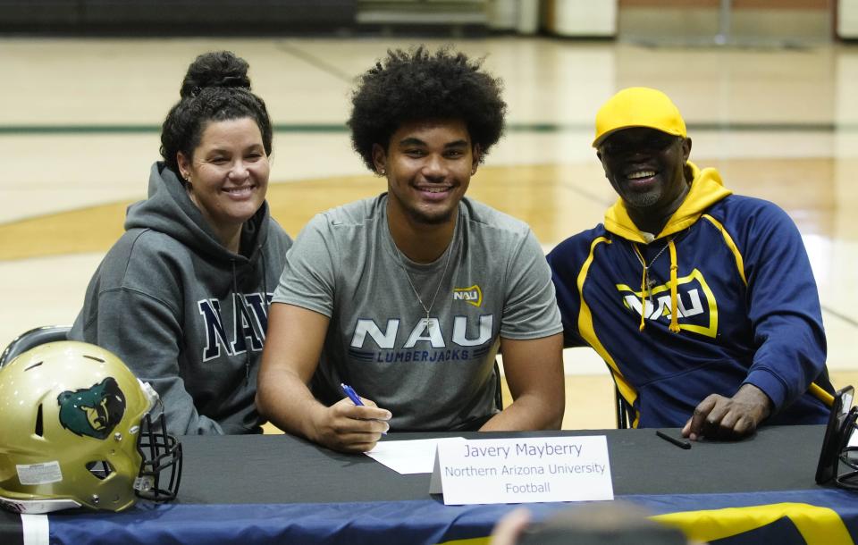 Basha tight end Javery Mayberry smiles with his family after signing his NIL during the NIL signing at Basha High School on Dec. 20, 2023, in Chandler.