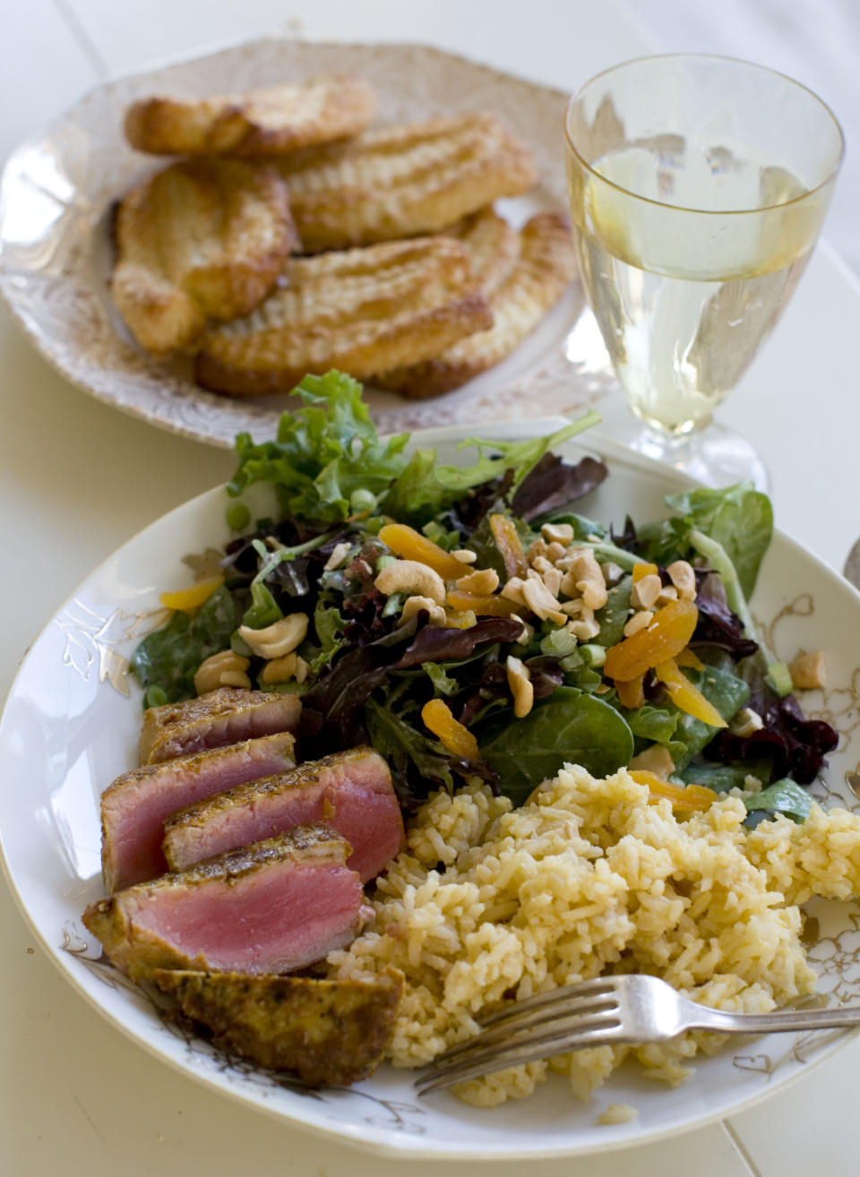 This Nov. 18, 2013 photo shows coconut cashew salad with apricots, seared curry rubbed tuna with mango tahini rice, and tangerine twirls in Concord, N.H. It's a mash-up that draws on the flavors of the Caribbean, Southeast Asia and Europe. (AP Photo/Matthew Mead)