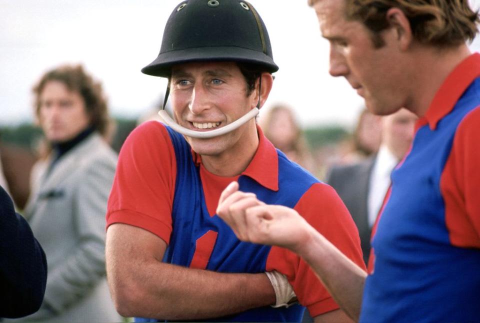 King Charles smiling in a riding helmet