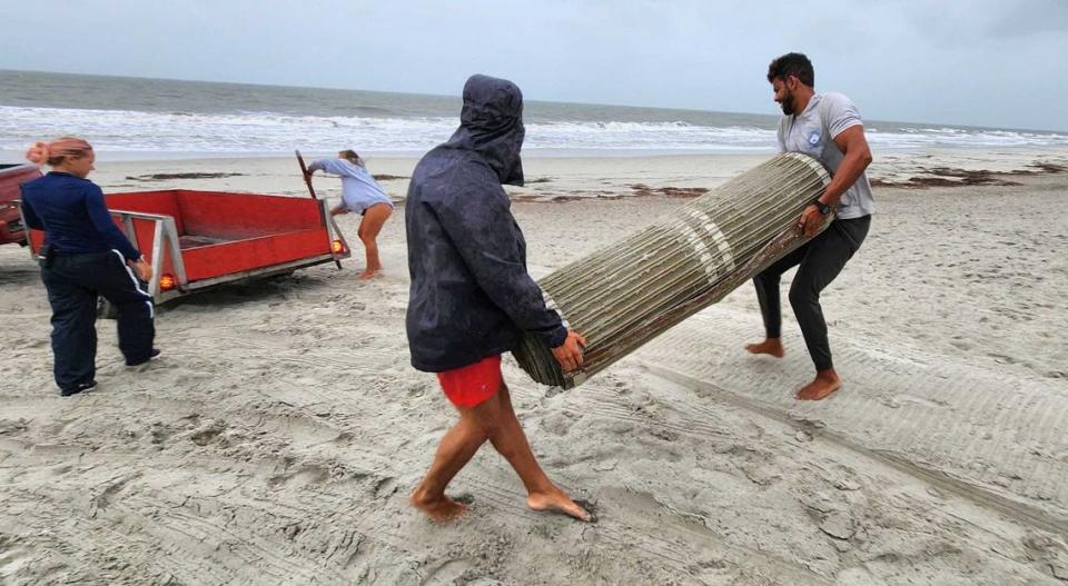 Members with Shore Beach Service Hilton Head Island remove a portion of the beach mat from Burkes Beach on Wed., Aug. 30, 2023 before the evening’s super high tide due to the blue moon and the arrival of Hurricane Idalia. Asked how many more mats they had to retrieve, a lifeguard said, “So many.”