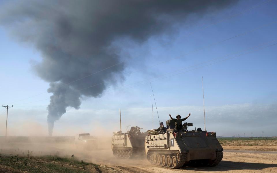 Israeli soldiers on army armored personnel carriers (APC) near the Israeli-Gaza border